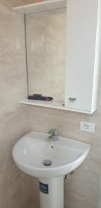 a white sink in a bathroom with a mirror at I Love Koman Camping in Shkodër