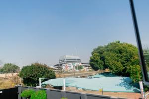 a view of a pool with a building in the background at Kilimanjaro Lodge Bed & Breakfast in Johannesburg