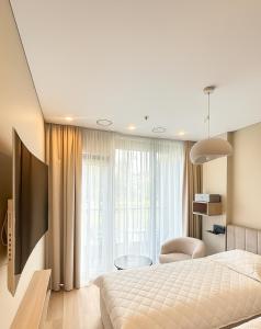 a bedroom with a bed and a large window at Pušų natos in Druskininkai