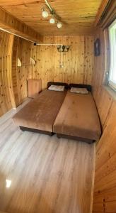 a large bed in a wooden room in a cabin at 50m od Jeziora - Dom wakacyjny in Zawóz