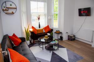 a living room with a couch and a table at SmartStay, Fast Wifi and Workspace, 3 Beds, Central, Private Parking, by Airport in Farnborough