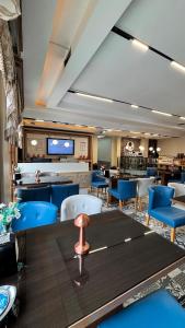 a restaurant with blue chairs and a table and a bar at ECRİN OTEL in Uzungöl
