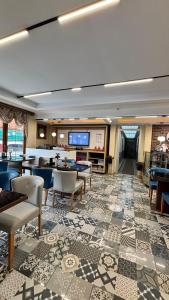 a hotel lobby with tables and chairs and a flat screen tv at ECRİN OTEL in Uzungöl