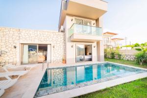 a villa with a swimming pool in front of a house at Villa Meyra in Kaş