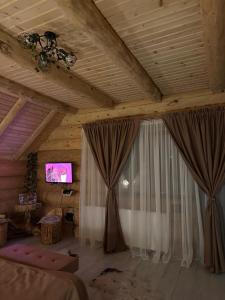 a living room with curtains and a tv on a ceiling at Chalet in Muntii Vrancei - Gresu - Lepsa cu Ciubar si Sauna in Greşu
