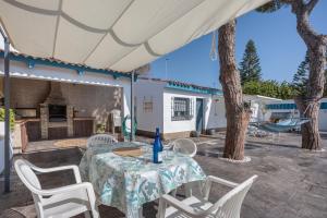 une terrasse avec une table, des chaises et une balançoire dans l'établissement Melkart loft Sancti Petri, à Chiclana de la Frontera