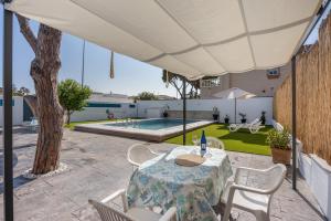 un patio avec une table et des chaises et une piscine dans l'établissement Melkart loft Sancti Petri, à Chiclana de la Frontera