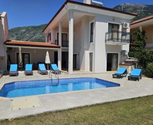 a villa with a swimming pool in front of a house at Cloud Villa Olu Deniz in Fethiye