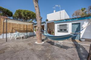 un hamac bleu suspendu à un arbre dans une cour dans l'établissement Melkart loft Sancti Petri, à Chiclana de la Frontera