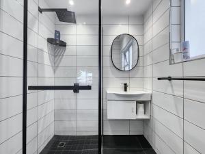 a white tiled bathroom with a sink and a mirror at Oasis in Seapoint in Cape Town +23 photos