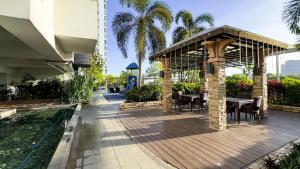 a pavilion with tables and chairs next to a pool at Cozy & Modern 2BR Unit in Manhattan Cubao with Balcony in Sampong
