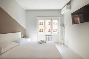 une chambre blanche avec un lit blanc et une fenêtre dans l'établissement Vatican Suites, à Rome