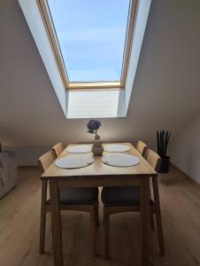a dining room table with chairs and a skylight at Eva apartments & free-parking in Klaipėda