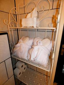 a towel rack with white towels and toilet paper at SUITE THE BLESSING "Where Heaven Touches Earth" in Bruges