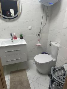 a white bathroom with a toilet and a mirror at Kalia A7 Sunny Beach in Bŭnzareto +9 photos