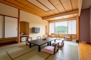 a living room with a table and chairs and a large window at Rantei in Sendai