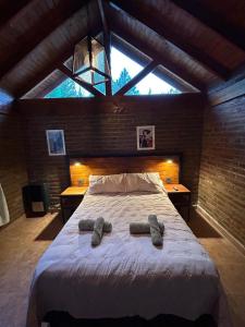a bedroom with a large bed with two slippers on it at casa pie de la montaña in Esquel