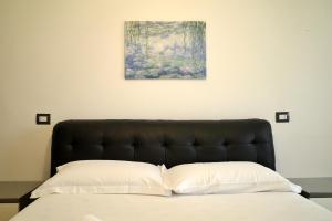 a bedroom with a bed and a painting on the wall at BWR - Bilocale a Cornaredo ---vicino Rho Fiera--- in Cornaredo +42 photos
