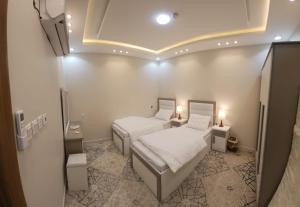 a small room with two beds and a tv at مرفق ضوء القمر السياحي بالباحة in Al Baha