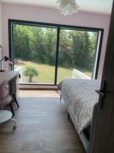 a bedroom with a bed and a large window at Jacasse Retreat - Elegant Architect Villa Nestled in Provencal Forest in Fuveau +57 photos