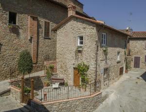 een stenen gebouw met een hek ervoor bij Tuttomio Home&Breakfast Suite with whirlpool in Castiglion Fiorentino