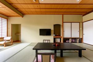 a living room with a table and a tv at Rantei in Sendai