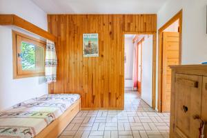 ein Schlafzimmer mit einem Bett und einer Holzwand in der Unterkunft Les Arolles n°G54 in Valloire