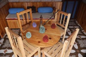 a wooden table with two chairs and a bed at Bhaskar Villa in Sainj