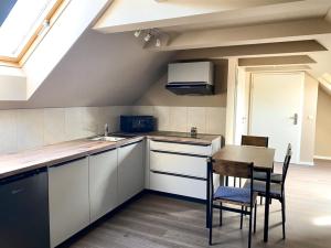 a kitchen with white cabinets and a table and chairs at Ferienwohnungen Lily, Bärwalder See, Ferienwohnung "SEE" in Klein Uhyst