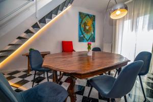 une salle à manger avec une table en bois et des chaises bleues dans l'établissement Suite Scacco Terrazza Vista Torre degli Sciri, à Pérouse 39 autres photos