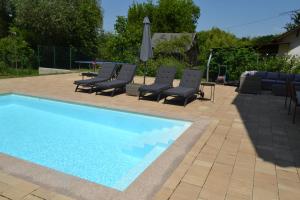 una piscina con lettini e un ombrellone di Krisztina Apartman Balatonberény a Balatonberény