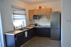 una cucina con mobili in legno e un frigorifero in acciaio inossidabile di Krisztina Apartman Balatonberény a Balatonberény