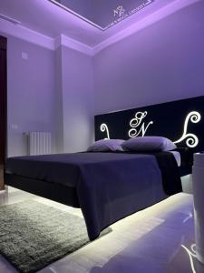 フォッジャにあるSN Luxury Room & Spaのベッドルーム1室(紫色の照明が付いた大型ベッド1台付) +6枚の写真