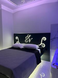フォッジャにあるSN Luxury Room & Spaの紫色のヘッドボードが付いた黒いベッドのある寝室