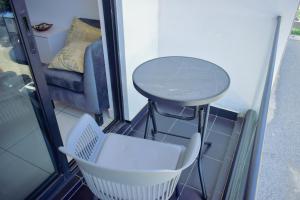 a small table and chair on a balcony with a couch at Lovely studios at Embassy Gardens in Accra