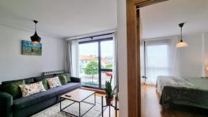 a living room with a couch and a bed and a window at Apartamento El Castro de Borizu in Celorio +42 photos