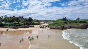a group of people standing on a beach at Apartamento El Castro de Borizu in Celorio