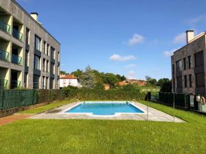 a swimming pool in a yard next to a building at Apartamento El Castro de Borizu in Celorio