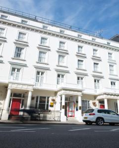 een wit gebouw met een auto ervoor geparkeerd bij Best Western Corona Hotel in Londen
