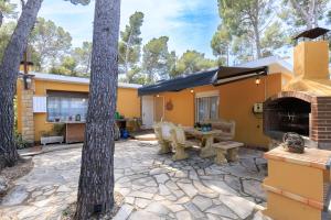 an outdoor patio with a table and a fireplace at Villa Frades in Salou