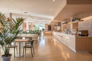 a large kitchen with a table and chairs at Sol de Alcudia Apartamentos in Port d'Alcudia