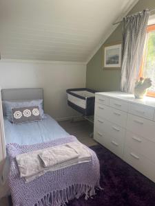 a bedroom with a bed and a dresser at Villa med panoramautsikt, stor uteplass og 100 m fra badestrand in Bergen