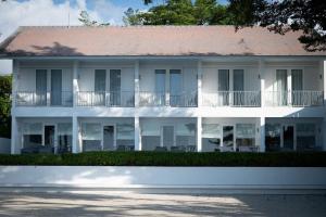ein weißes Gebäude mit einem roten Dach in der Unterkunft Lusa Beach Studios Under New Management And Newly Renovated in Lovina