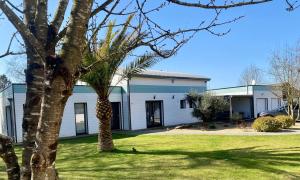 a house with a palm tree in the yard at Chambre Viviane in Néant-sur-Yvel