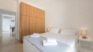 a bedroom with a white bed with towels on it at Vounala Studio in Pollonia