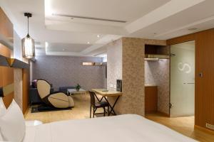 ein Hotelzimmer mit einem Bett und einem Esszimmer in der Unterkunft Surreal Motel in Xinzhuang