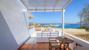 a balcony with a table and chairs and the ocean at Vounala Studio in Pollonia