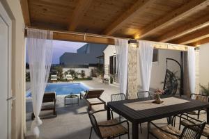 eine Terrasse mit Tisch und Stühlen und einem Pool in der Unterkunft Villa Ridollin in Pula