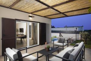 eine Terrasse mit weißen Stühlen und einer Holzdecke in der Unterkunft Villa Ridollin in Pula