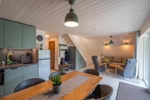 una cucina e un soggiorno con tavolo e sedie in legno di Tuhamäe hosteli puhkemajad a Kiviõli